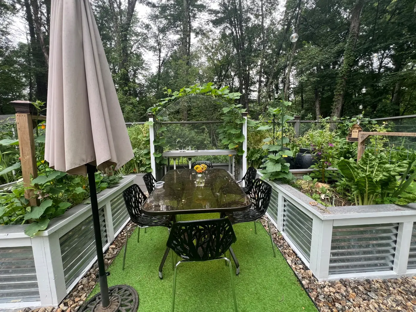 Dining table surrounded by productive raised vegetable beds