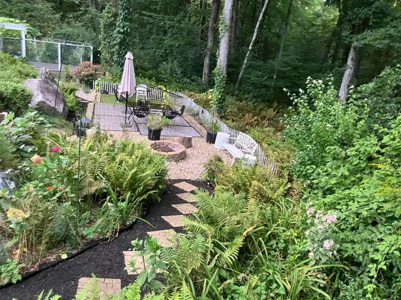 Winding garden path leading through a lush garden to an outdoor sitting area