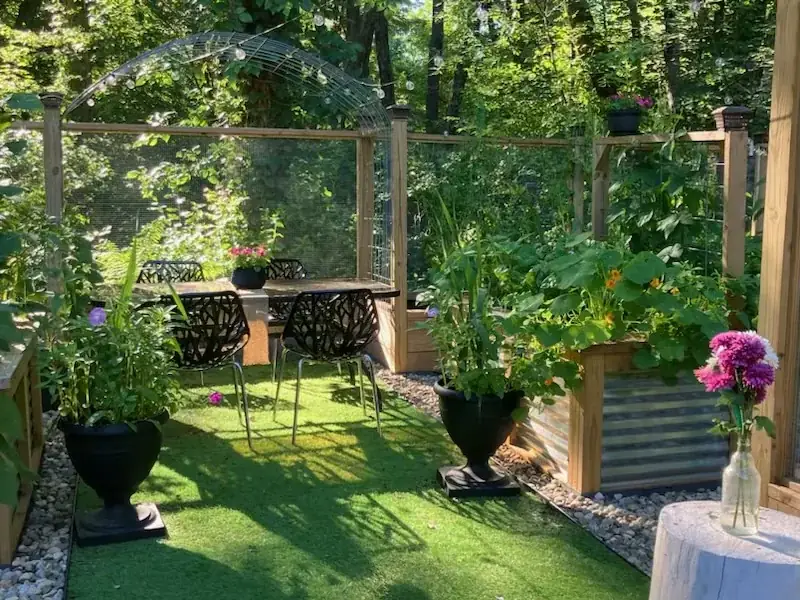 Garden dining area surrounded by raised beds and climbing plants