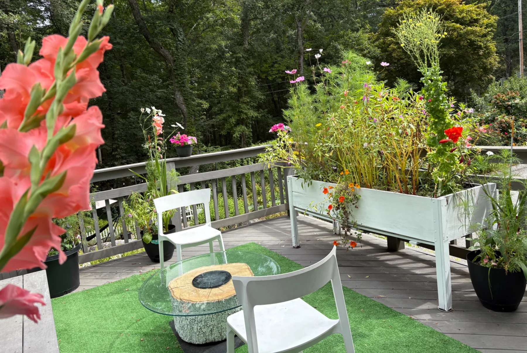 Flower-filled raised garden on a deck with outdoor seating